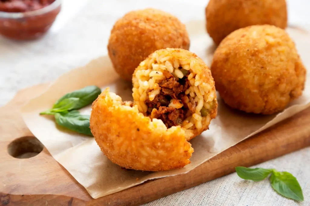 Italian food that is not pizza or pasta, arancini one that is broken open.